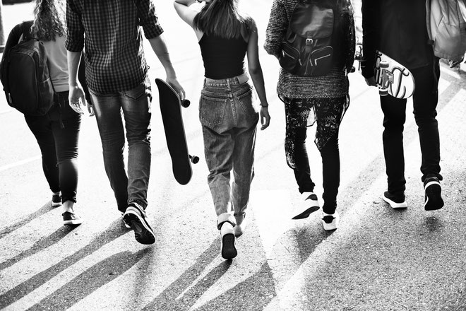groupe-de-5-adolescents-qui-marchent-dans-la-rue-vue-de-dos