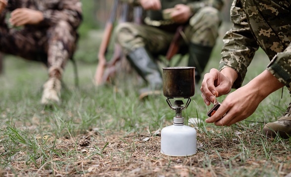 Man Sets Fire of Portable Gas Burner with Match.